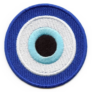 May include: Embroidered patch featuring a blue and white evil eye design. The patch has a circular shape with a dark blue outer border, a white inner circle, and a light blue and black eye in the center. The patch is designed to be sewn or ironed onto fabric.