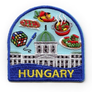 May include: Embroidered patch with a blue border and the word "HUNGARY" in yellow letters. The patch features a building with a green dome, a Rubik's Cube, a pen, and four plates with various foods.