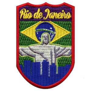 Puede incluir: Parche bordado con borde rojo, fondo morado y el texto "Rio de Janeiro" en amarillo. El parche presenta una bandera brasileña verde y amarilla con una estatua blanca de Cristo Redentor en el centro. La parte inferior del parche muestra un paisaje urbano azul.