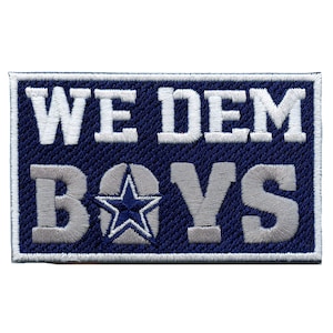 May include: A blue and white embroidered patch with the text "WE DEM BOYS" and a white star inside a circle.