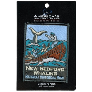 May include: A gray embroidered patch with a blue background depicting a whale being harpooned by a whaling boat. The text "New Bedford Whaling National Historical Park" is printed below the image. The patch is labeled "America's National Parks Collector's Series".