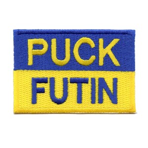 May include: A yellow and blue embroidered patch with the text "PUCK FUTIN" in yellow letters.