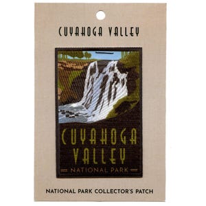 Puede incluir: Un parche bordado marrón y verde con una imagen de una cascada y el texto "Cuyahoga Valley National Park".