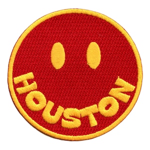 May include: Red embroidered patch with a yellow smiley face and the word "HOUSTON" in yellow lettering.