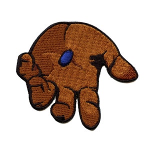 Peut inclure: Un patch brodé marron représentant une main avec un pouce bleu, parfait pour ajouter une touche unique à vos vêtements ou accessoires.