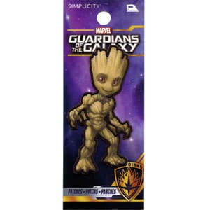 Puede incluir: Parche para planchar con una imagen de dibujos animados de Groot de Guardianes de la Galaxia. El parche es marrón y verde y tiene un fondo morado con estrellas. El texto "MARVEL GUARDIANS OF THE GALAXY" está en la parte superior del parche.