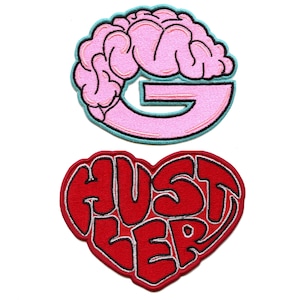 Pode incluir: Dois patches bordados para passar a ferro. O primeiro patch é um cérebro rosa em forma da letra G. O segundo patch é um coração vermelho com a palavra "Hustler" escrita dentro.
