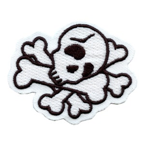 May include: White embroidered skull and crossbones patch with brown stitching. The skull has a frowning expression and a single eye.