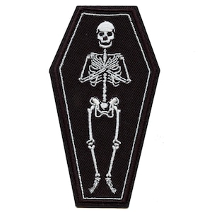 May include: White embroidered skeleton in a black coffin shaped patch.