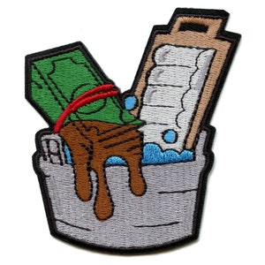May include: An embroidered patch depicting a bucket with a stack of bills and a bar of soap inside. The bills are tied with a red rubber band and are partially submerged in brown liquid. The soap is white and has a brown wooden handle. The bucket is gray with a black rim.