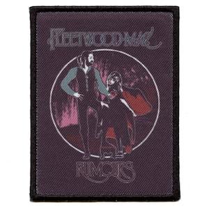 Op de afbeelding: Een zwart-wit geweven patch met de tekst "Fleetwood Mac" en een silhouet van twee mensen voor een roze en paarse achtergrond. De tekst "Rumors" staat onderaan de patch.