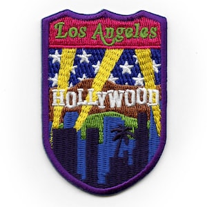 May include: Purple, blue, green, yellow and white embroidered patch with the text "Los Angeles" and "HOLLYWOOD" in a shield shape.