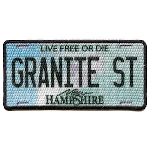 May include: A blue and white patch with black text that reads "Live Free or Die" and "Granite St" with the words "New Hampshire" below.