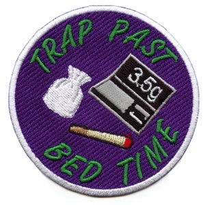 May include: Purple round embroidered patch with white stitching. The patch features a white bag, a scale with a digital display reading "3.59", a lit cigarette, and the text "TRAP PAST BED TIME" in green.