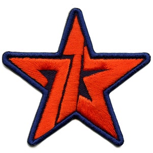 May include: Red embroidered star with a blue outline. The star has a stylised letter "T" inside.