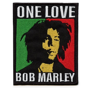May include: Black and white embroidered patch with a portrait of Bob Marley, the words "One Love" and "Bob Marley" in white text, and a red, green, and yellow background.