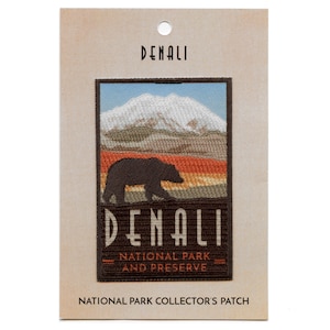 May include: A brown and tan embroidered patch with a mountain range, a bear, and the text "Denali National Park and Preserve".