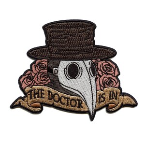 May include: Embroidered iron-on patch featuring a plague doctor wearing a hat and a long beak mask. The patch has a banner that reads "The Doctor Is In" with pink roses on either side.