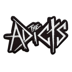May include: A black and white embroidered patch with the text "The Adicts" in a stylised font.