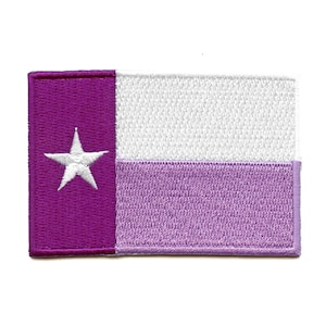 May include: Embroidered patch featuring a design with a purple vertical stripe on the left, a white horizontal stripe in the middle, and a light purple horizontal stripe at the bottom. A white star is in the purple stripe. The patch is rectangular.