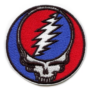 May include: A round embroidered patch featuring the iconic Grateful Dead Steal Your Face logo. The skull is outlined in black with a white face and a lightning bolt in red, white, and blue.