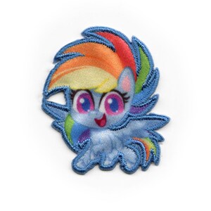 May include: A blue and rainbow embroidered patch featuring a cartoon pony with a rainbow mane and tail. The pony has large blue eyes and a pink nose.