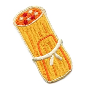 May include: An embroidered iron-on patch of a yellow burrito with red and white details. The burrito is tied with a white string.