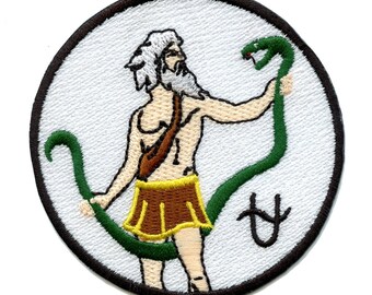 May include: Embroidered patch featuring a white background with a black outline. A cartoon image of a man with a white beard holding a green snake. The snake is coiled around the man's legs. The symbol for the zodiac sign Virgo is embroidered in white in the lower right corner.