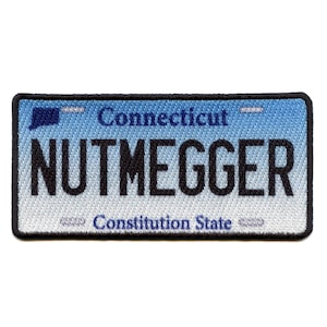 Puede incluir: Parche bordado que se asemeja a una placa de matrícula de Connecticut. El parche presenta un diseño azul y blanco con la palabra "NUTMEGGER" en letras negras. También se ven los textos "Connecticut" y "Constitution State".
