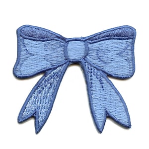 May include: A light blue fabric bow with a satin finish. The bow is tied in a knot with two long tails.