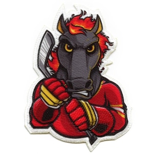 Può includere: Una toppa ricamata con un cavallo di cartone animato che indossa una maglia da hockey rossa e tiene un bastone da hockey. Il cavallo ha una criniera infuocata e un'espressione feroce, con accenti neri e gialli.