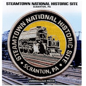 Puede incluir: Parche bordado con una imagen en blanco y negro de una locomotora de vapor sobre un fondo amarillo. El texto "STEAMTOWN NATIONAL HISTORIC SITE SCRANTON, PA" está escrito en un círculo alrededor de la locomotora.