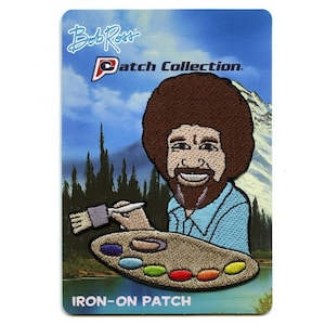 May include: Iron-on patch featuring a cartoon illustration of Bob Ross painting with a paintbrush and palette. The patch has a blue background with a mountain scene and the text "Bob Ross Patch Collection".
