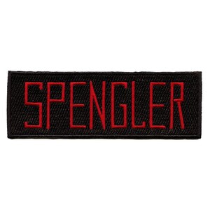 May include: Black embroidered patch with the word "SPENGLER" in red lettering.