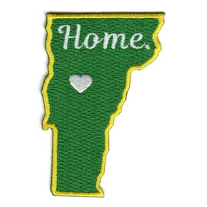Op de afbeelding: Groen geborduurd patch in de vorm van de staat Vermont met een gele rand. Het woord "Home" is in wit geborduurd op het patch. Een wit hart is geborduurd in het midden van het patch.