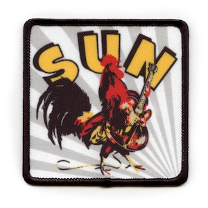 May include: A red rooster with a black tail feathers playing a yellow electric guitar with the word "SUN" in yellow letters behind it. The image is on a white background with gray stripes.