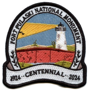 May include: Embroidered patch featuring a lighthouse with a beam of light shining from the top, a red brick wall, and a banner with the text "Fort Pulaski National Monument 1924 - Centennial - 2024".