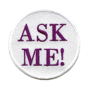 May include: White round embroidered patch with purple text that reads "ASK ME!"