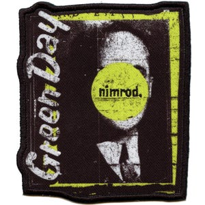 May include: A black and yellow embroidered patch with the words "Green Day" and "Nimrod" on it. The patch features a black and white image of a person with a yellow circle over their face.