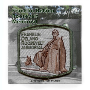 May include: Embroidered patch with a green border and a white background. The patch features a depiction of Franklin Delano Roosevelt, with the text "FRANKLIN DELANO ROOSEVELT MEMORIAL" above him. The patch also includes the text "EMBROIDERED PATCH" at the bottom.