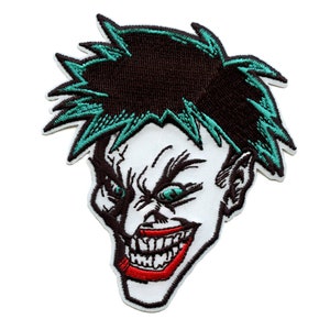 May include: Embroidered patch of a grinning, white-faced character with green hair and a red smile. The character has a menacing expression with dark eyebrows and green eyes.