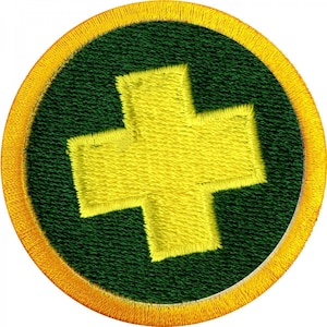 May include: A round, yellow-bordered patch with a green background and a large yellow plus sign in the center.