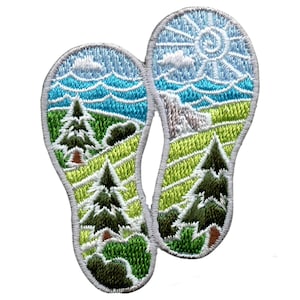 May include: White embroidered patch with two footprints. Each footprint has a landscape scene with green trees, blue sky, and a yellow sun.