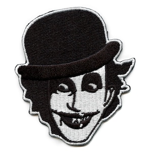 May include: Black and white embroidered patch of a character wearing a black bowler hat with a sinister smile.