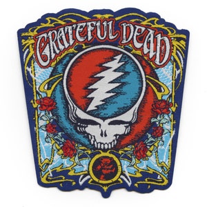 Puede incluir: Un parche bordado en azul, amarillo y rojo con las palabras "Grateful Dead" y un diseño de calavera y rayo.