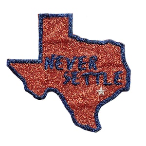 May include: A red glitter outline of the state of Texas with a blue border and the words "Never Settle" in blue lettering. A white star is in the centre of the state.