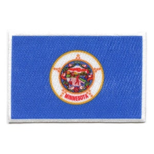 Op de afbeelding: Een blauwe patch met een witte rand met het staatszegel van Minnesota. Het zegel is een cirkel met een gouden rand en toont een inheemse Amerikaan die een vredespijp vasthoudt en een witte ster erboven. De woorden "MINNESOTA" staan op een gouden banner onder het zegel.
