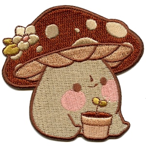 May include: Embroidered patch of a brown mushroom with a white flower on top. The mushroom has a smiling face and is holding a small potted plant.