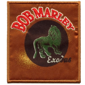 Könnte beinhalten: Ein brauner Stoff-Patch mit einem roten gestickten Rand. Der Patch zeigt einen grünen Löwen, der auf einem schwarzen Kreis steht, mit dem Text "BOB MARLEY" in roter Stickerei um den Kreis herum. Der Text "Exodus" ist in weiß unter dem Löwen gedruckt.