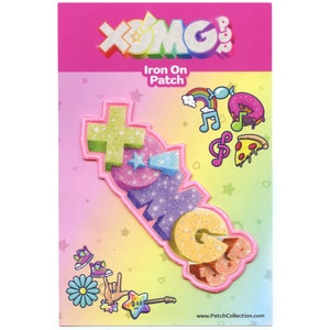 May include: A pink iron-on patch featuring the words "XOMG POP!" in colourful, glittery letters. The patch is surrounded by a pink border and a rainbow background. The text "Iron On Patch" is printed above the patch.